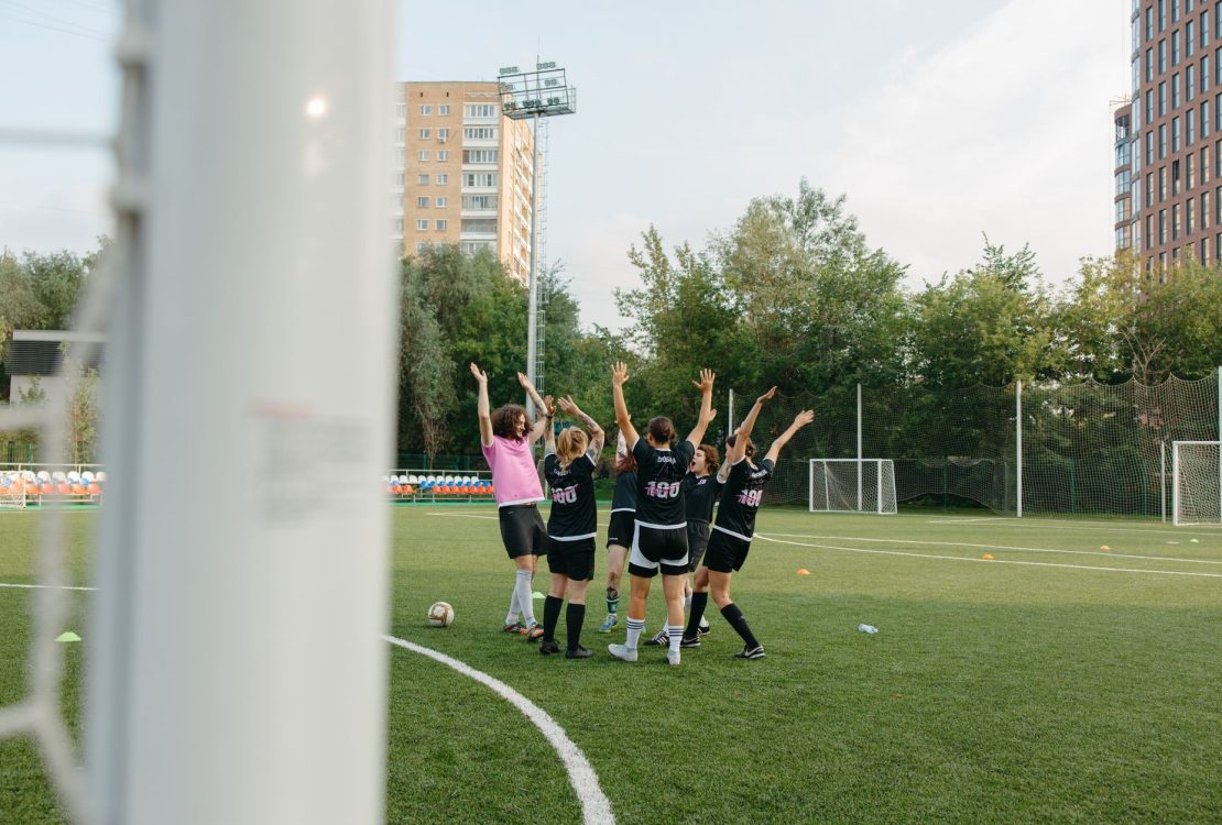 Jogadoras de futebol feminino comemoram juntas uma vitória em campo.