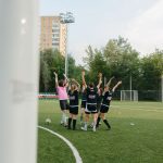 Jogadoras de futebol feminino comemoram juntas uma vitória em campo.
