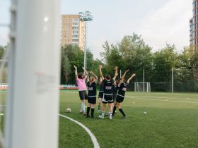 Jogadoras de futebol feminino comemoram juntas uma vitória em campo.