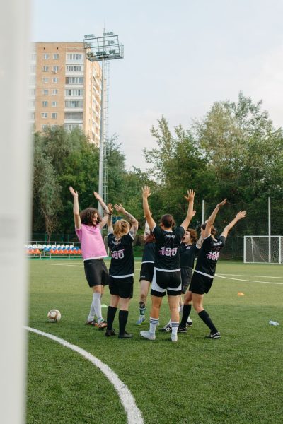 Jogadoras de futebol feminino comemoram juntas uma vitória em campo.
