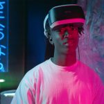 Pessoa usando óculos de realidade virtual iluminada por luzes neon em um ambiente escuro.