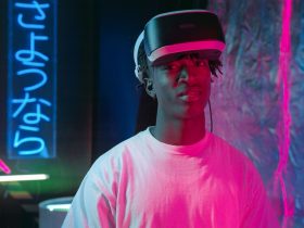 Pessoa usando óculos de realidade virtual iluminada por luzes neon em um ambiente escuro.